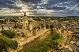 Vue d'une rue pavée animée d'Arlon avec plomberie du quartier Plombier Arlon, bâtiments anciens et boutiques locales