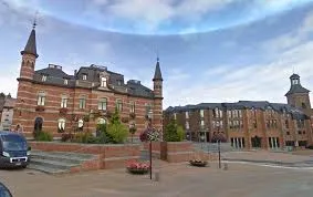 Débouchage Frameries devant l'église de la Sainte-Vierge, architecture locale typique, rue bordée de maisons traditionnelles.