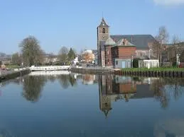 Plombier La Louvière en intervention près du centre historique avec vue sur une rue pavée typique et bâtiments en brique.