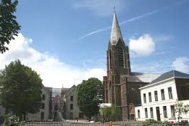 Rue animée de Manage avec plombier en intervention Débouchage Manage bâtiments typiques et passants locaux