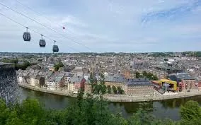 Plombier Namur devant la citadelle historique et les rues pavées du centre-ville animées par des commerces locaux