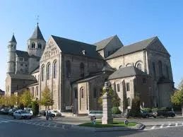 Plombier Nivelles devant la collégiale Sainte-Gertrude, cœur historique de la ville belge, rue pavée et bâtiments anciens.