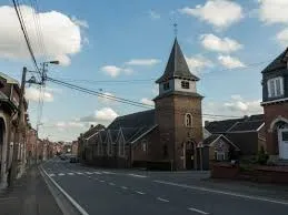 Plombier Oupeye réparant une canalisation proche de l'église Saint-Remy dans une rue typique de Oupeye en Belgique