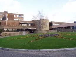 Rue animée de Sambreville avec bâtiments historiques, scénographie de Débouchage Sambreville en action.